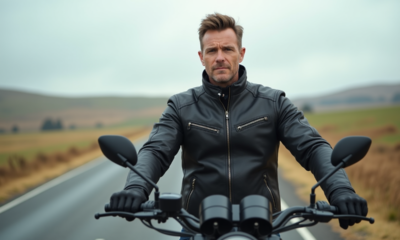 Homme en veste de moto à côté d'une moto moderne sur une route rurale